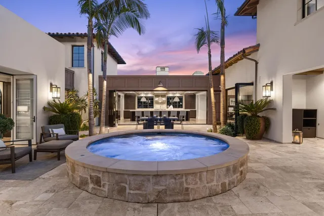 a view of a house with a swimming pool and sitting area