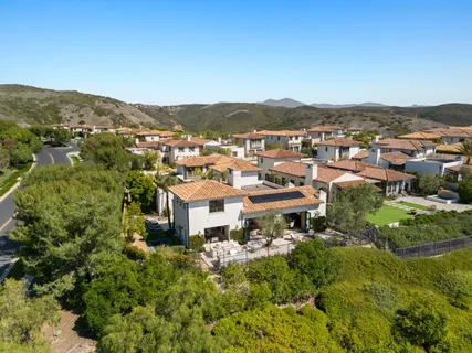 an aerial view of residential house with parking and trees