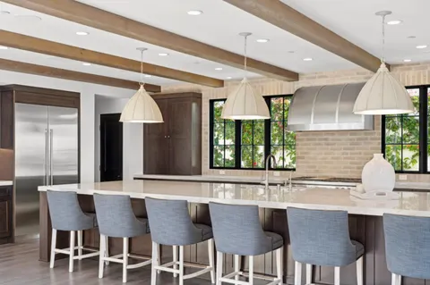 a kitchen with a dining table chairs and white cabinets