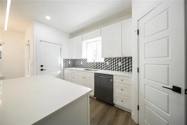 a kitchen with a refrigerator stove and white cabinets
