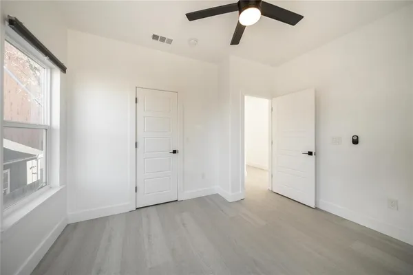 a view of an empty room with chandelier fan and fire place