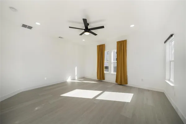 an empty room with fan and windows