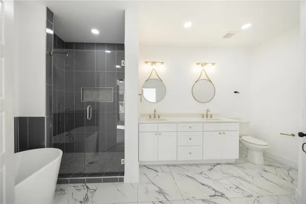 a bathroom with a double vanity sink mirror and toilet