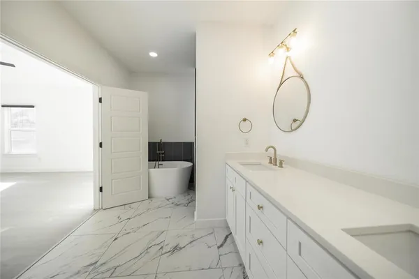 a spacious bathroom with a double vanity sink toilet mirror and shower