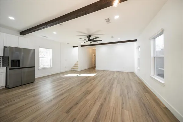 a view of empty room with wooden floor and window