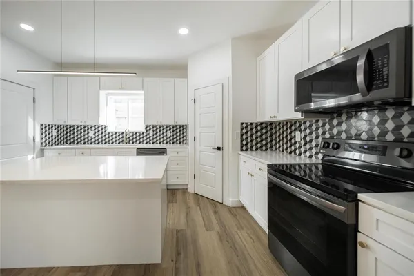 a kitchen with granite countertop a stove and a microwave