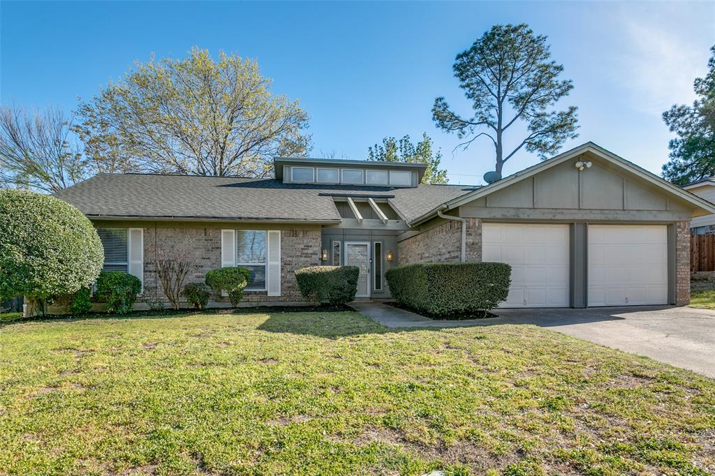 749 Spring Valley Drive Hurst, TX 76054 - Photo 1 of 1 View of front facade with an attached garage, brick siding, a front lawn, roof with shingles, and driveway