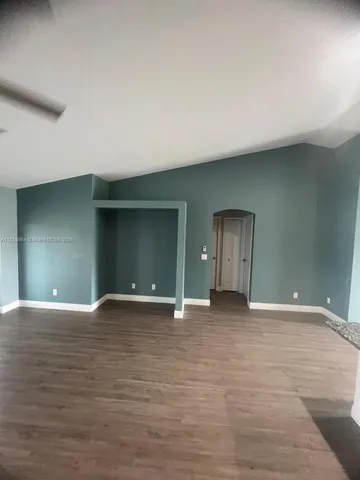a view of an empty room with closet and a window