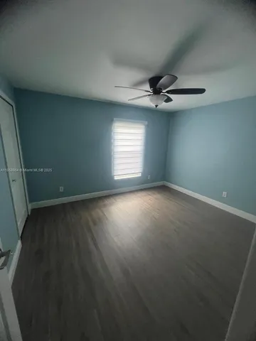 an empty room with a window and a ceiling fan
