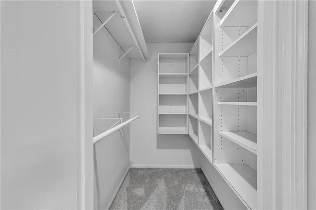 a view of walk in closet with empty racks