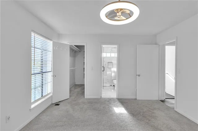 an empty room with a window and a chandelier