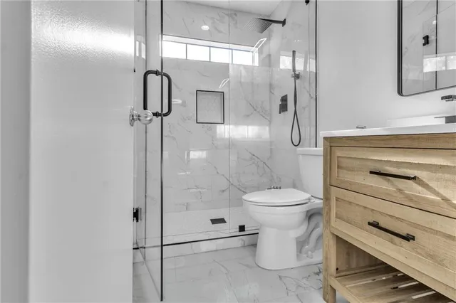 a bathroom with a toilet a sink and shower