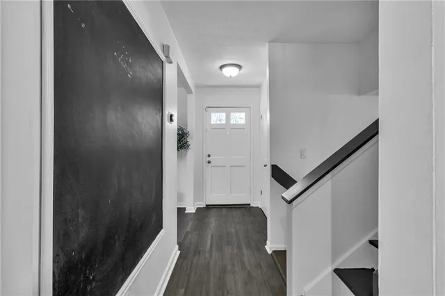 a view of a hallway with wooden floor and stairs