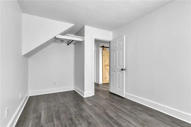 an empty room with wooden floor and a bathroom