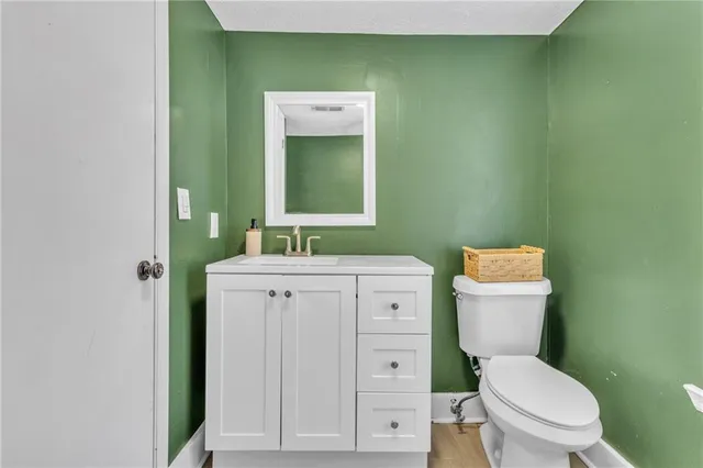 a bathroom with a toilet a sink and mirror