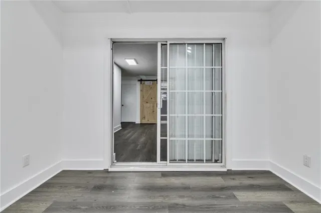 an empty room with wooden floor and entrance