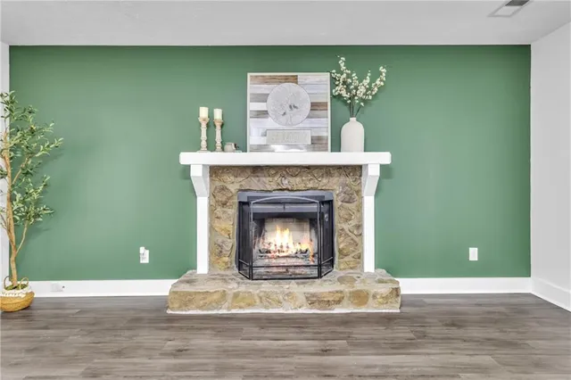 a living room with a fireplace and potted plant