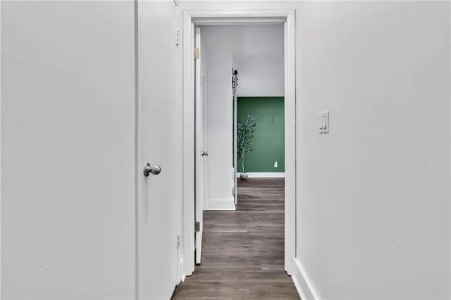 a view of a hallway with wooden floor and entryway