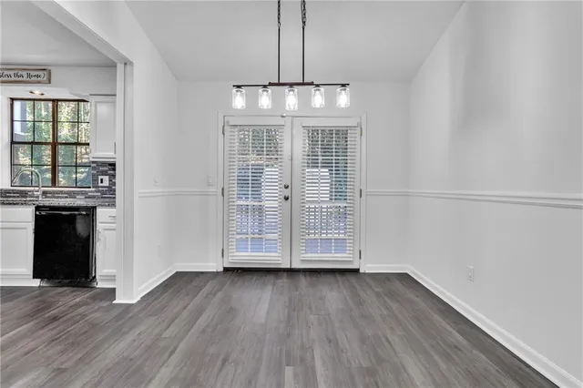 an empty room with wooden floor a ceiling fan and windows