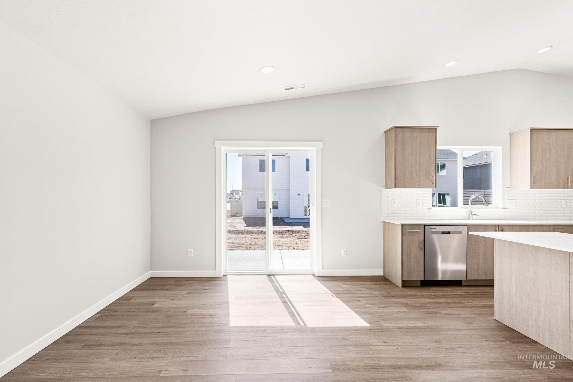 1077 West Jasper Street Meridian, ID 83642 - Photo 7 of 19 Open-concept living area featuring wood-finish flooring, recessed lighting, and a vaulted ceiling