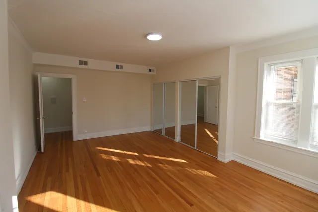 a view of an empty room with wooden floor