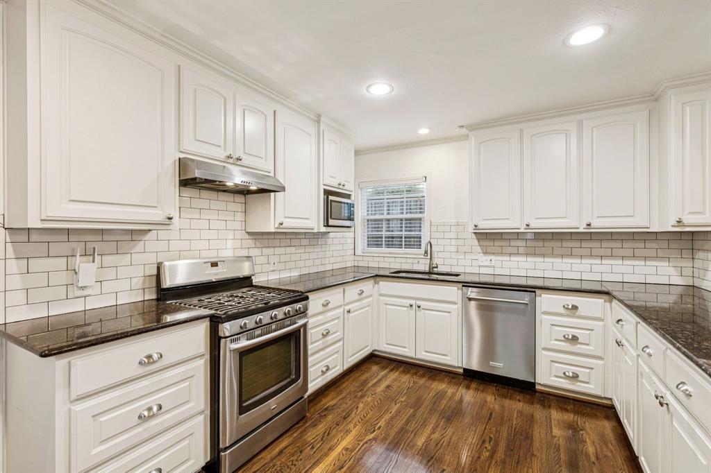 6342 Anita Street Dallas, TX 75214 - Photo 12 of 26 a kitchen with stainless steel appliances granite countertop a stove a sink and white cabinets