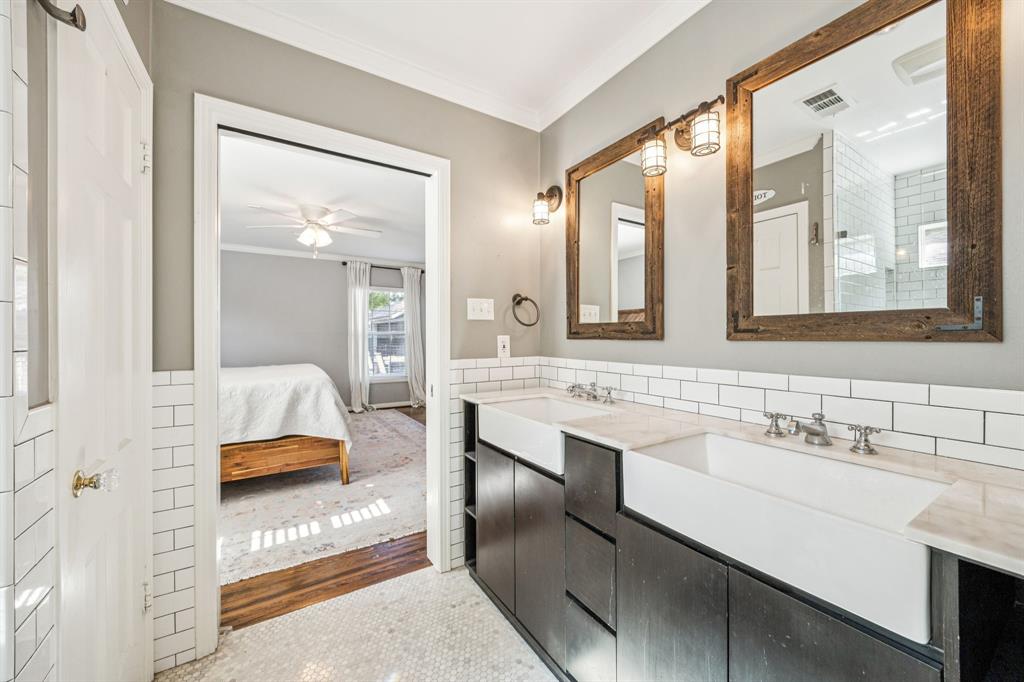 6342 Anita Street Dallas, TX 75214 - Photo 19 of 26 a en suite bathroom with a double vanity sink and mirror
