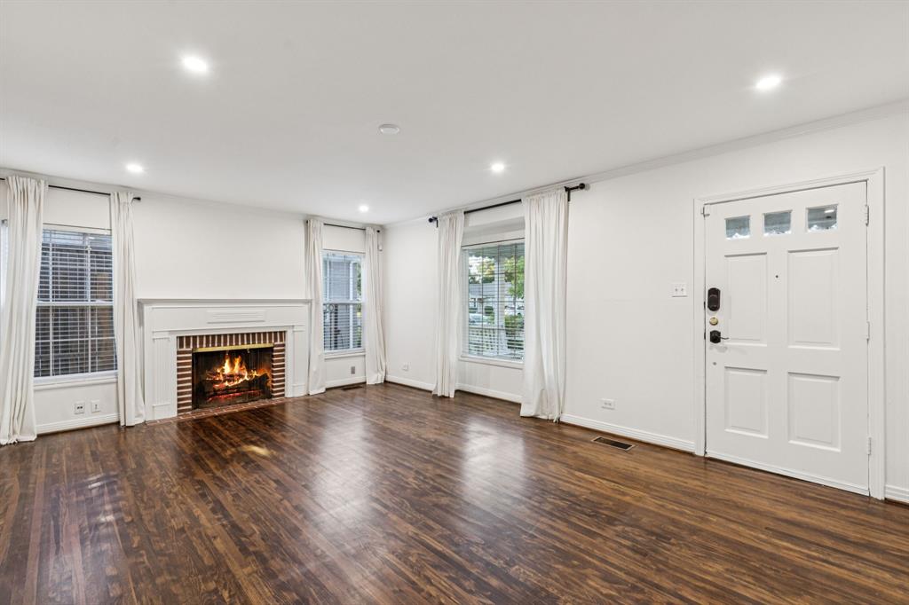 6342 Anita Street Dallas, TX 75214 - Photo 7 of 26 an empty room with wooden floor fireplace and windows