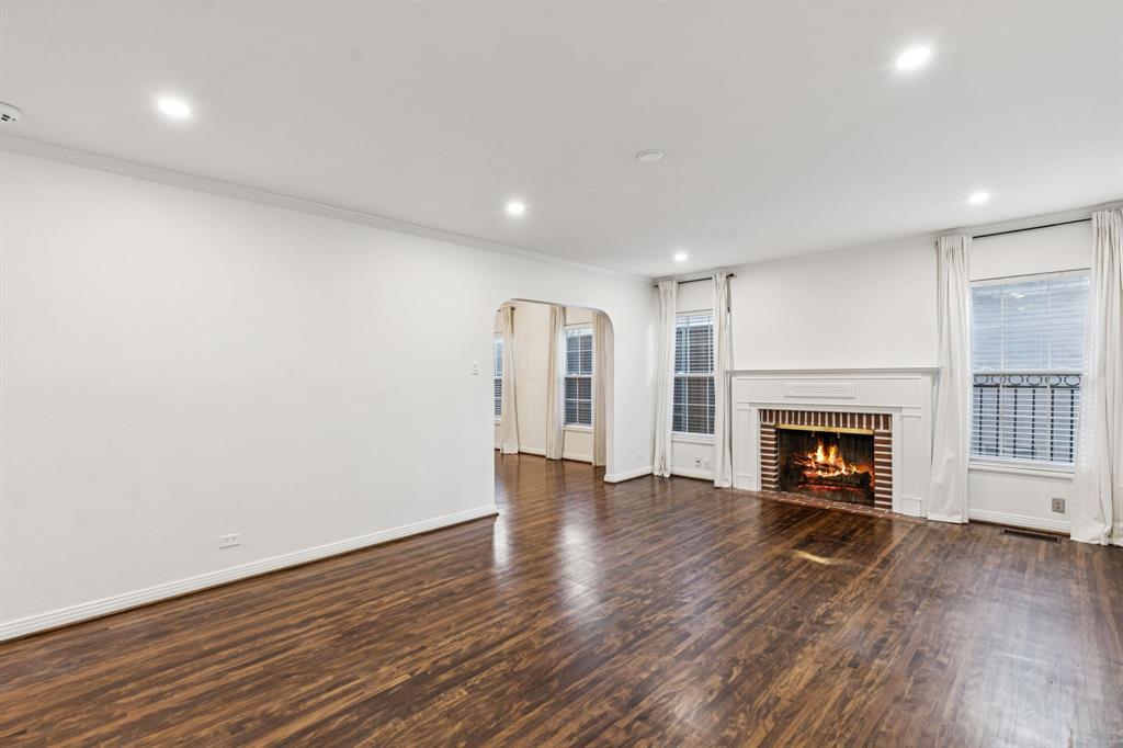 6342 Anita Street Dallas, TX 75214 - Photo 9 of 26 an empty room with wooden floor fireplace and windows