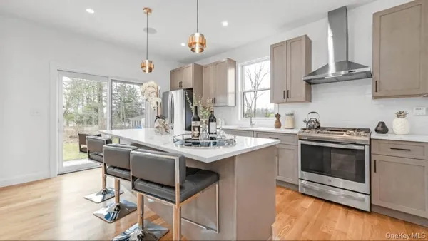 a kitchen with stainless steel appliances granite countertop a sink stove and wooden floor