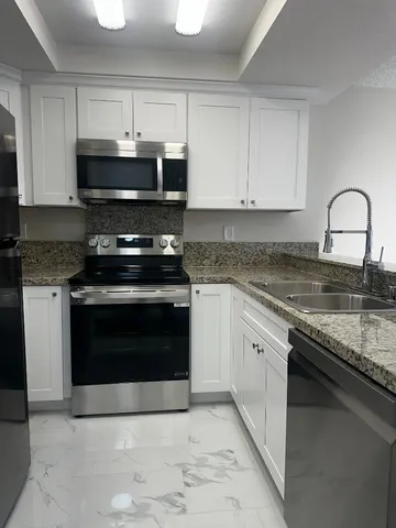 a kitchen with granite countertop a stove and a sink