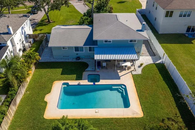 an aerial view of residential houses with outdoor space and trees