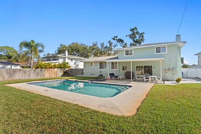 an aerial view of residential houses with outdoor space and trees