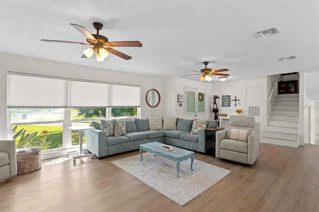 a open kitchen with cabinets a sink and a stove top oven with wooden floor