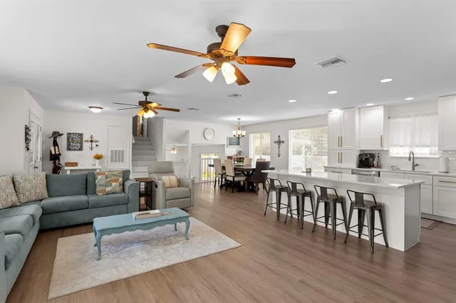 a kitchen with stainless steel appliances granite countertop a table chairs refrigerator and sink