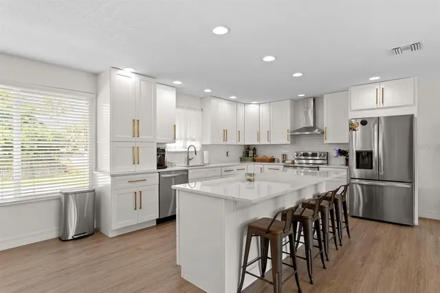 a kitchen with white cabinets and stainless steel appliances