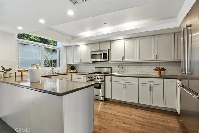 a kitchen with stainless steel appliances granite countertop a stove a sink and a microwave