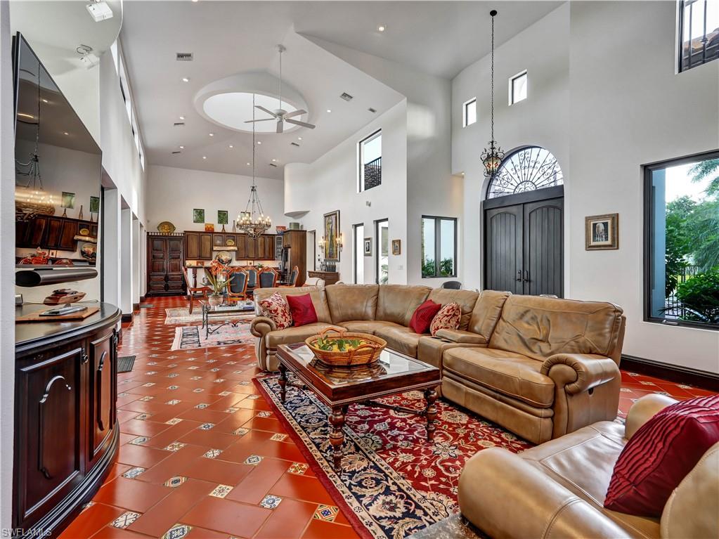 2535 Tarpon Road Naples, FL 34102 - Photo 4 of 50 Mediterranean-style residence featuring a terracotta tile roof, private swimming pool, waterfront access with a substantial dock, integrated boat lifts, and mature palm landscaping