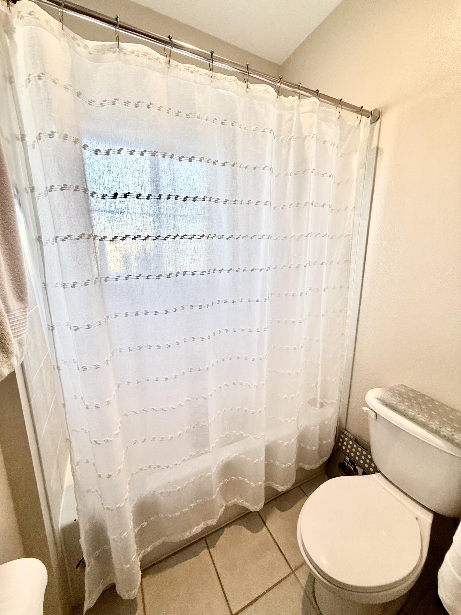 9745 Touchton Road, Unit 1726 Jacksonville, FL 32246 - Photo 17 of 40 a white toilet sitting next to a shower curtain