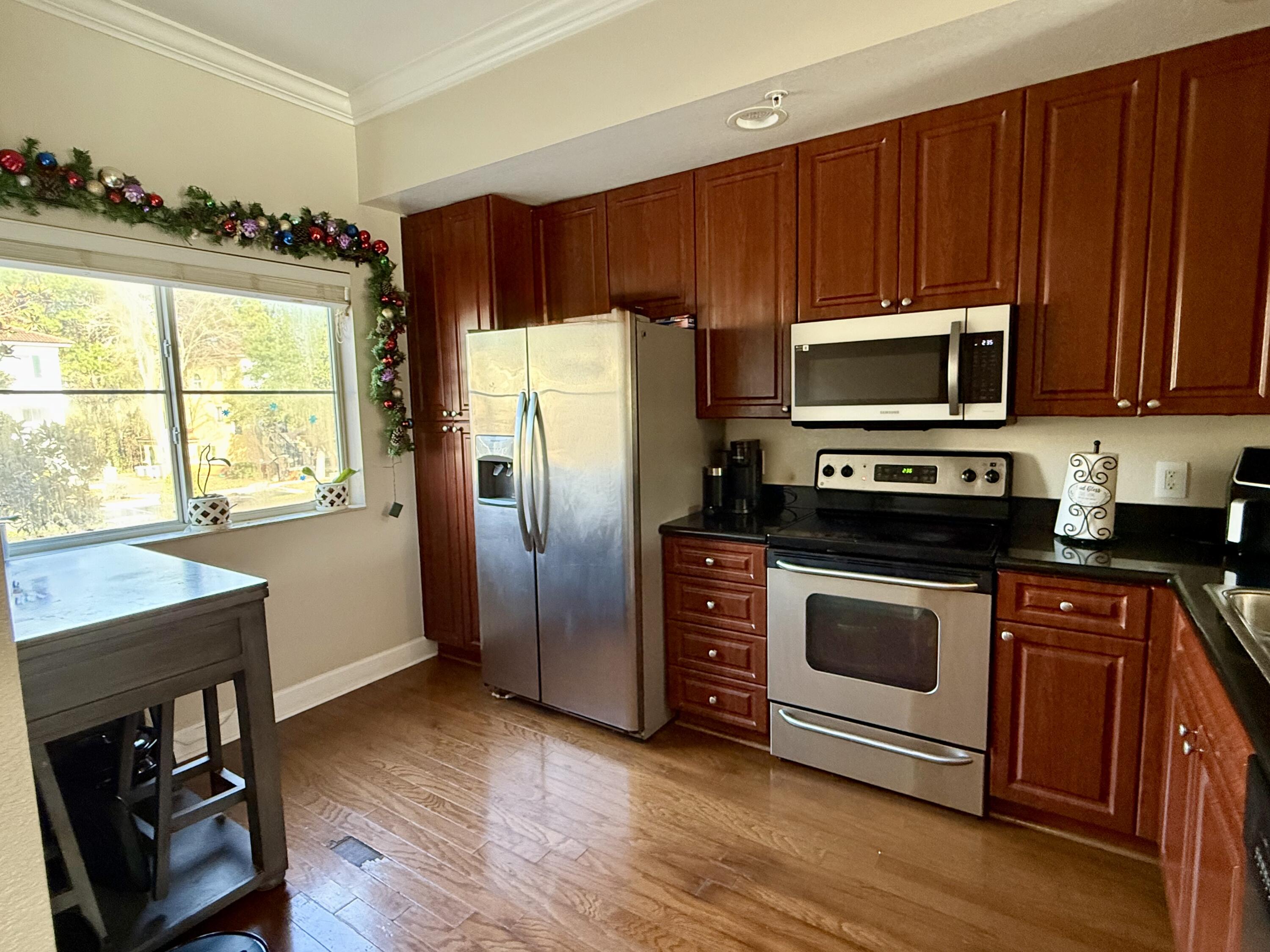 9745 Touchton Road, Unit 1726 Jacksonville, FL 32246 - Photo 4 of 40 a kitchen with granite countertop wooden cabinets stainless steel appliances and a window
