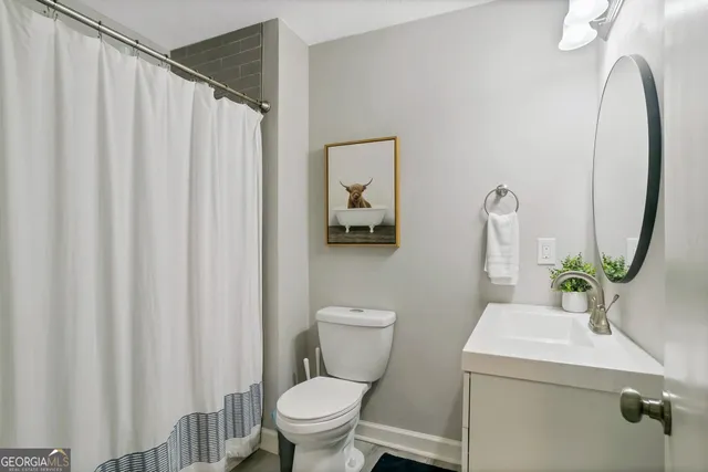 a bathroom with a sink mirror and toilet