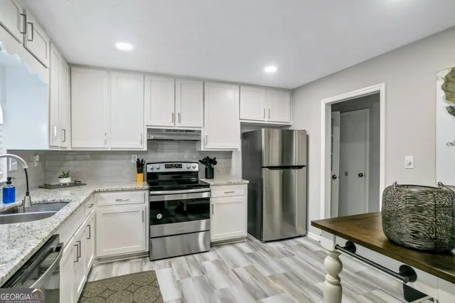 a kitchen with a sink stainless steel appliances and refrigerator