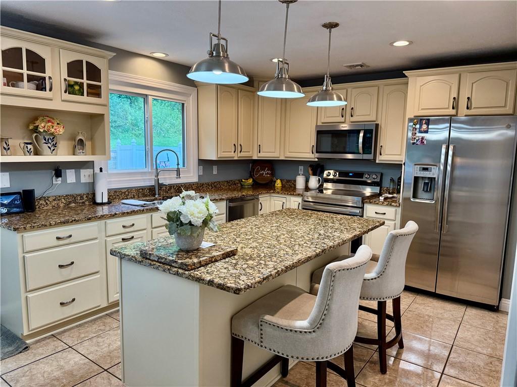 293 Sandy Hill Road Valencia, PA 16059 - Photo 27 of 50 a kitchen with stainless steel appliances granite countertop a stove a sink a microwave refrigerator and chairs