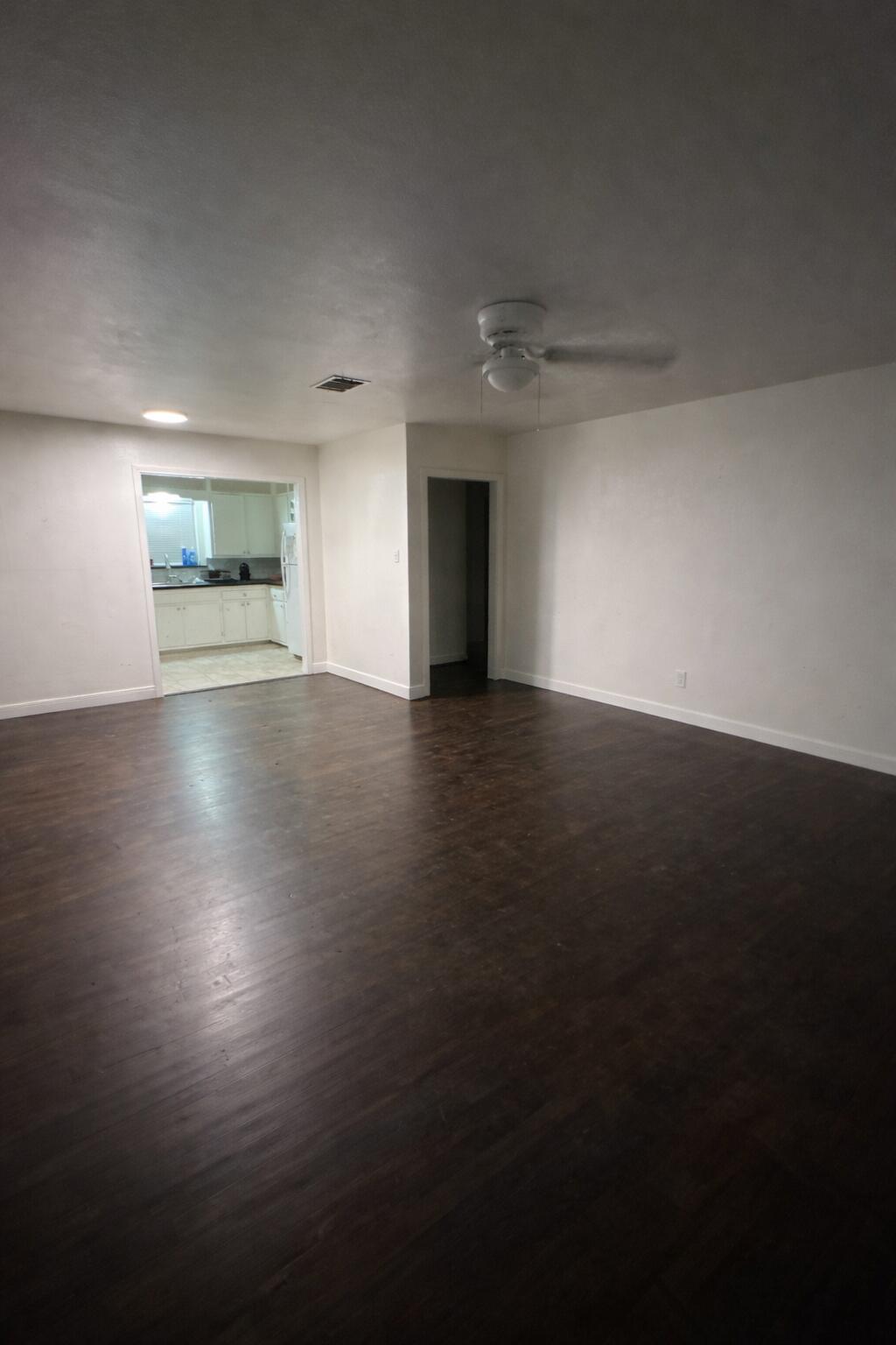 3116 33rd Street Lubbock, TX 79410 - Photo 2 of 7 an empty room with wooden floor and windows