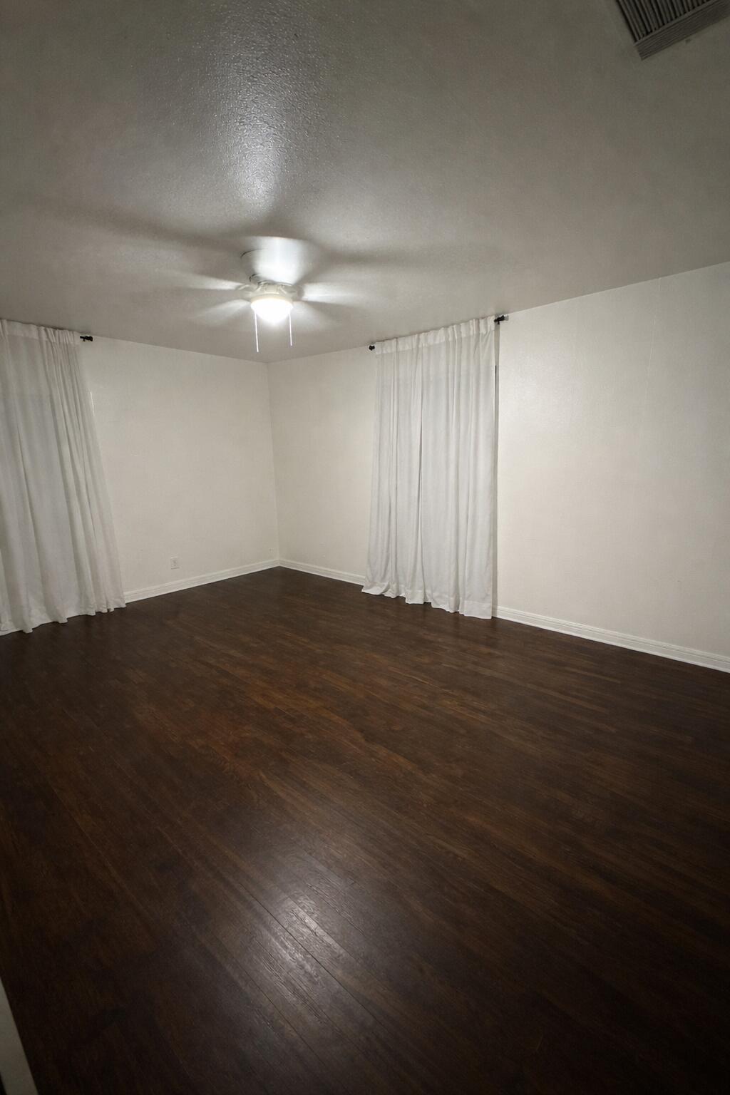 3116 33rd Street Lubbock, TX 79410 - Photo 6 of 7 an empty room with wooden floor and fan