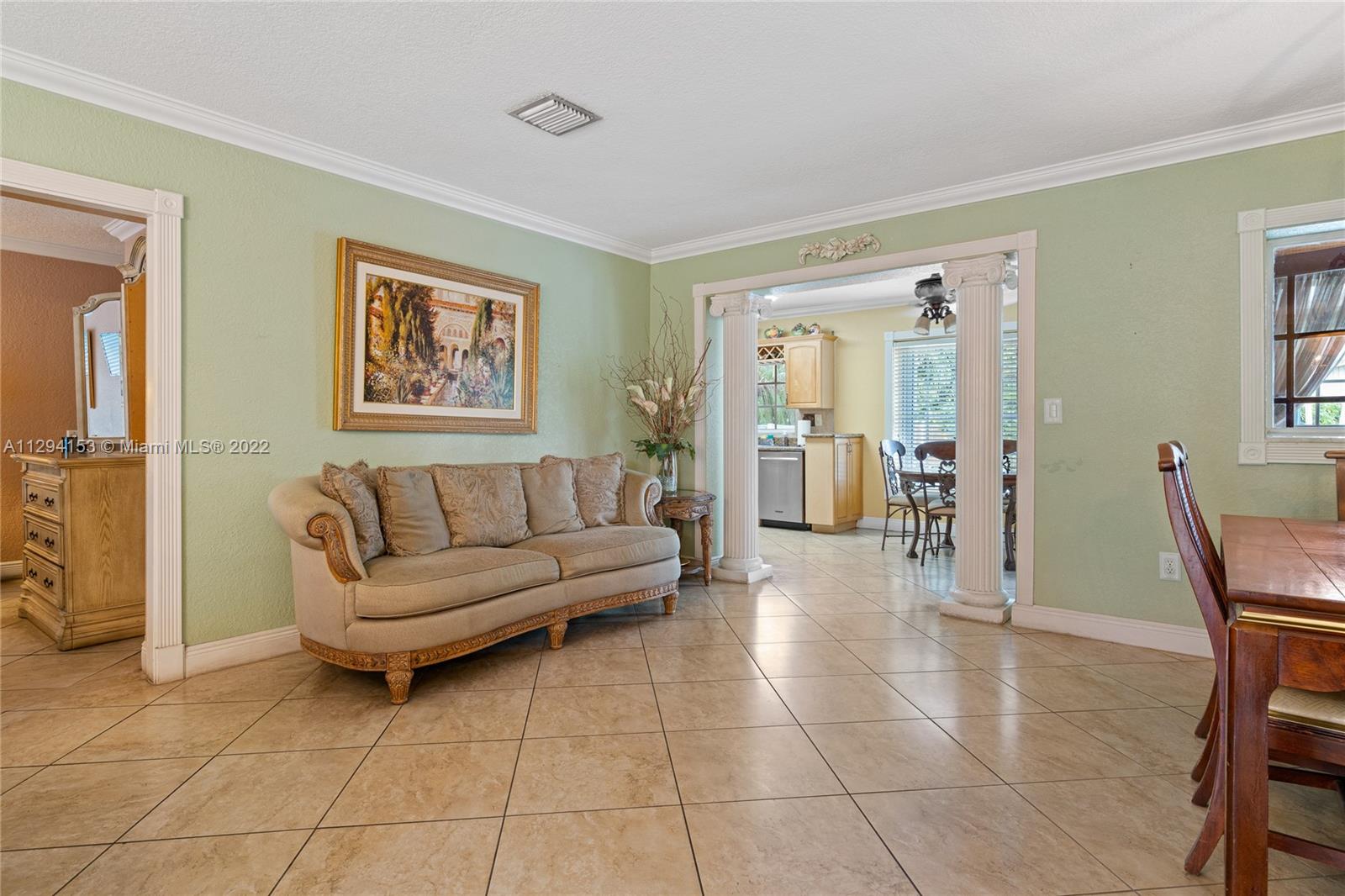 9901 Southwest 35th Terrace Miami, FL 33165 - Photo 14 of 50 a living room with furniture a dining table and a painting on the wall