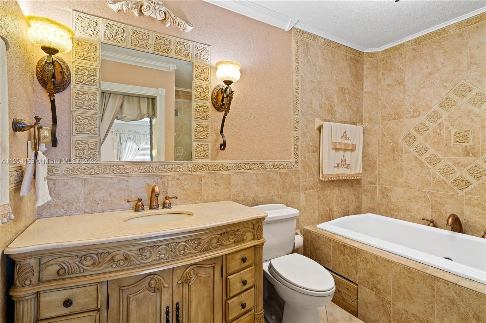 9901 Southwest 35th Terrace Miami, FL 33165 - Photo 19 of 50 a bathroom with a granite countertop toilet sink and mirror