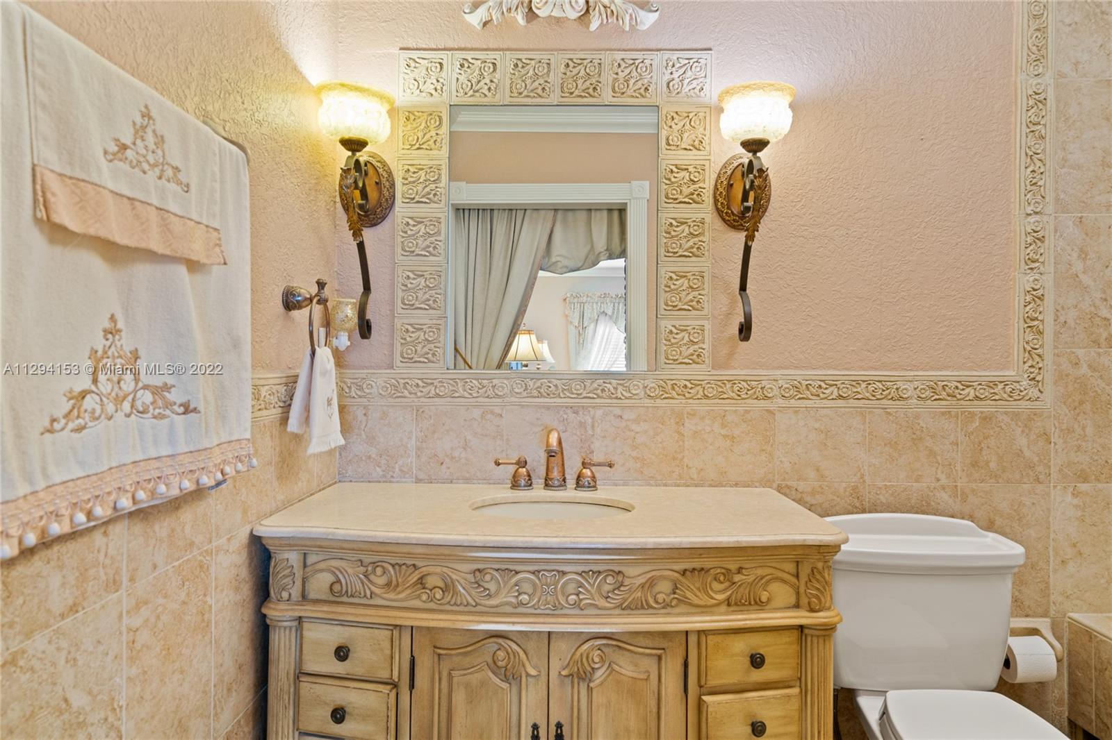 9901 Southwest 35th Terrace Miami, FL 33165 - Photo 21 of 50 a bathroom with a granite countertop sink a toilet and a mirror