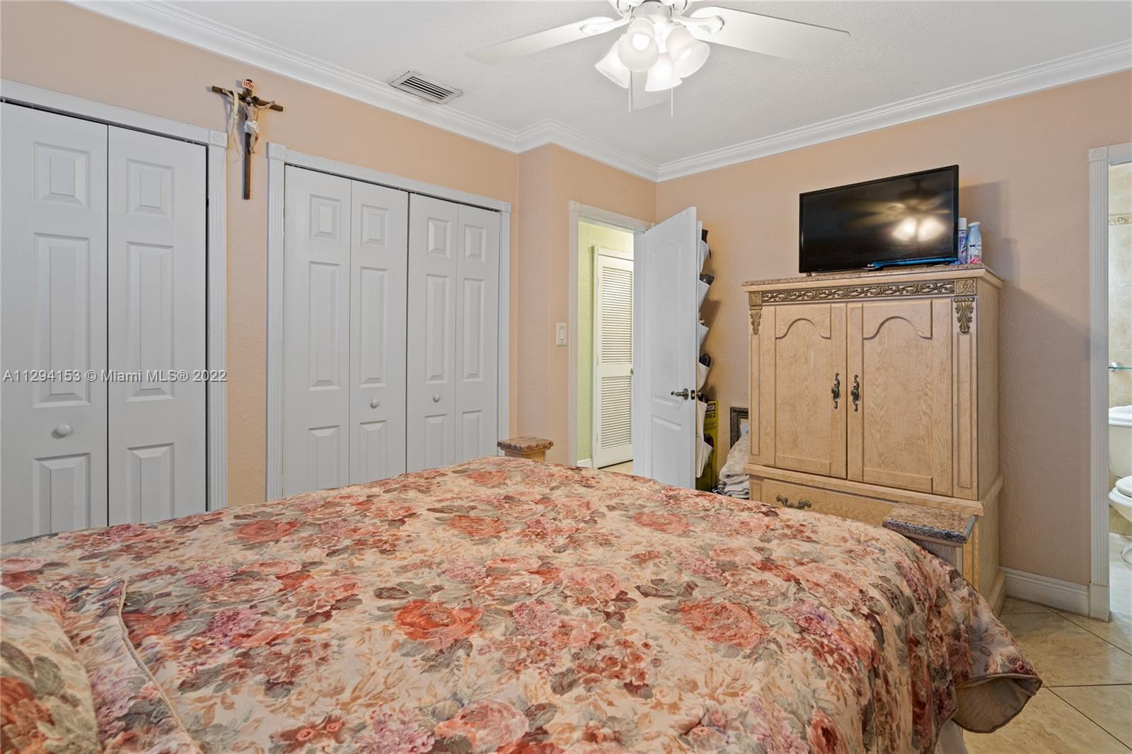 9901 Southwest 35th Terrace Miami, FL 33165 - Photo 26 of 50 a bedroom with a bed tv and wooden floor