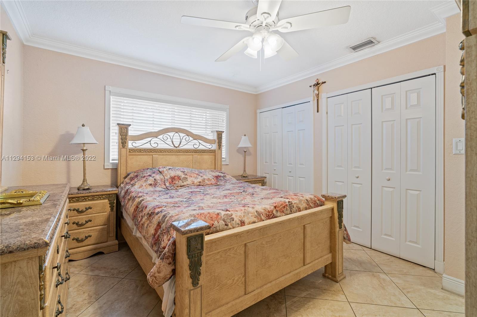 9901 Southwest 35th Terrace Miami, FL 33165 - Photo 28 of 50 a bedroom with a bed and a chandelier